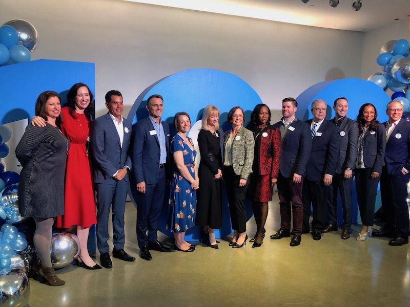 Katie Fallon in red, is a perfect example of how to leverage your personal traits in your job. Here with Hilton's top executives at a 100th birthday celebration media event. 