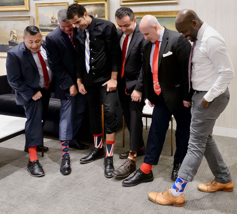 Male champions support women's career growth with red socks and ties on #RedTieTuesday